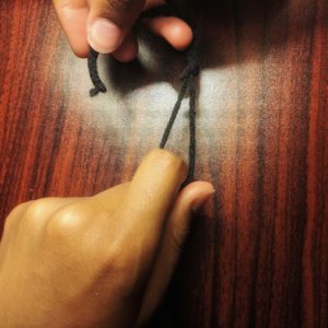 hands with yarn representing the incorrect way to interlock