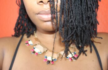 woman with half of her head and locs showing. has necklace on. article is about traction alopecia with locs.